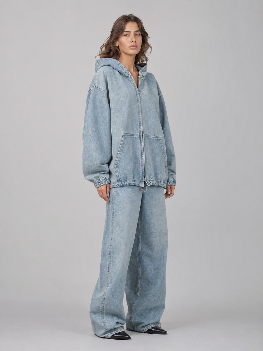 Veste en denim oversize portée en mouvement, volume des manches et de la capuche