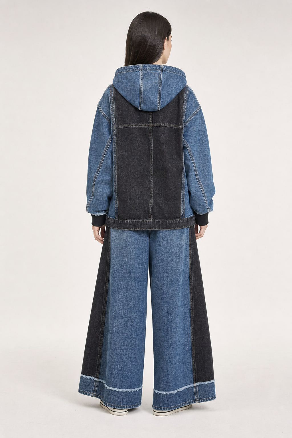 Dos de l'ensemble en denim, empiècements noir délavé sur la veste et jambe large