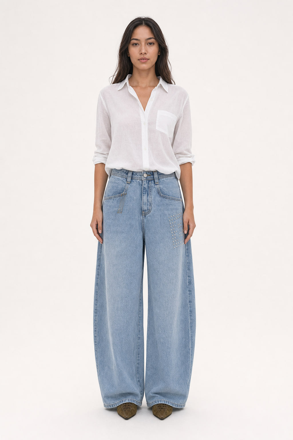 Jean large bleu clair délavé à jambe arrondie type cimeterre, taille mi-haute, avec clous métalliques sur la cuisse droite, vu de face