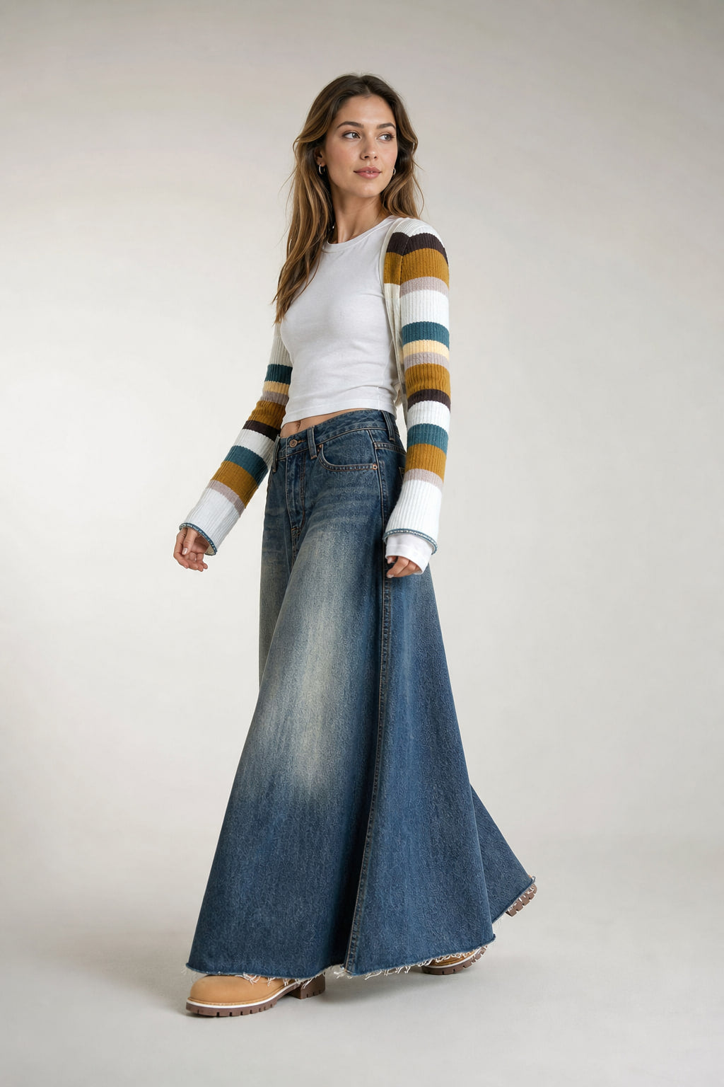 Jupe longue en denim délavé en mouvement, le bas évasé s'ouvre à la marche