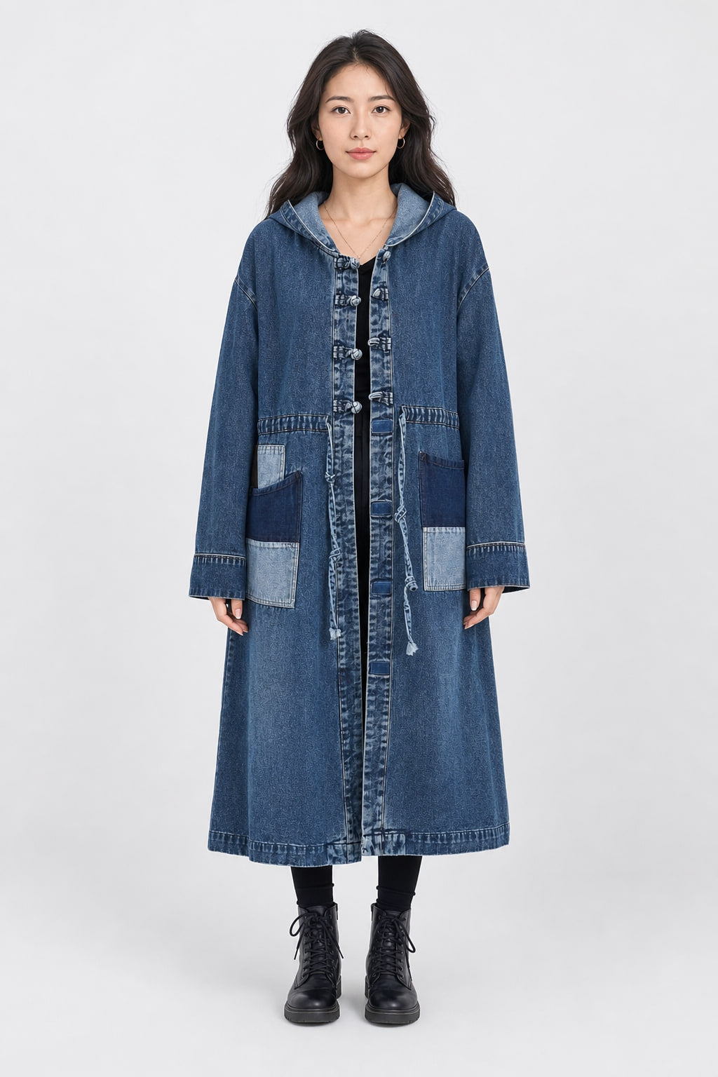 Manteau long en denim bleu délavé à capuche, vu de face, fermeture à brandebourgs et poches patchwork