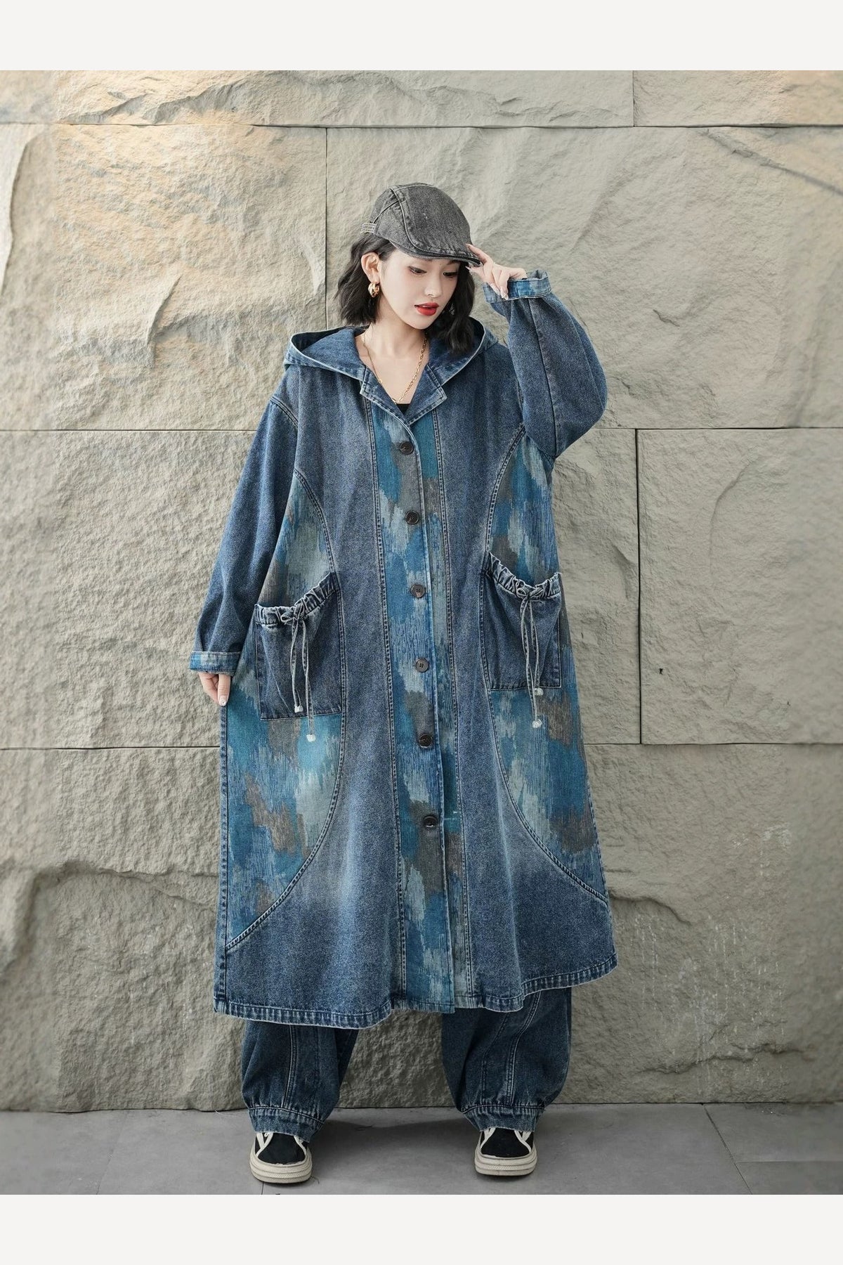 Manteau long denim vu de trois quarts droite, épaules tombantes et ligne évasée sous le genou