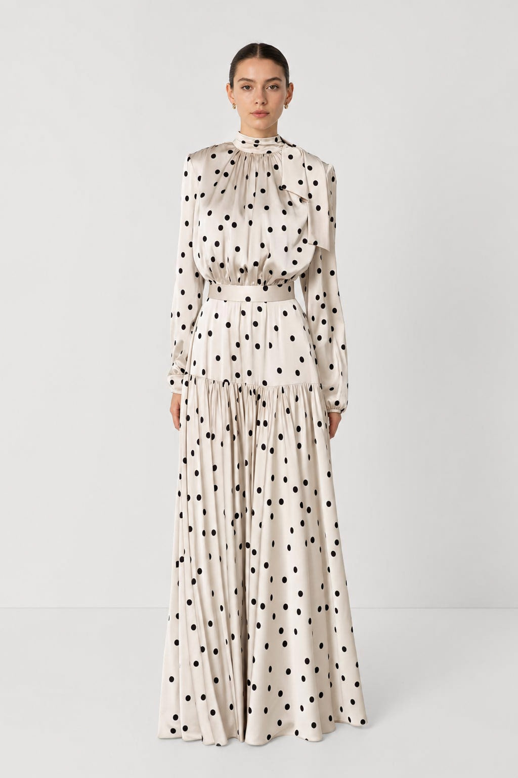 Robe longue satinée à pois noirs sur fond crème, vue de face, col montant et taille haute marquée