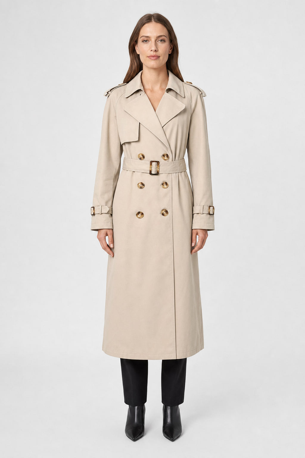 Trench long marron clair à double boutonnage vu de face, ceinture nouée à la taille