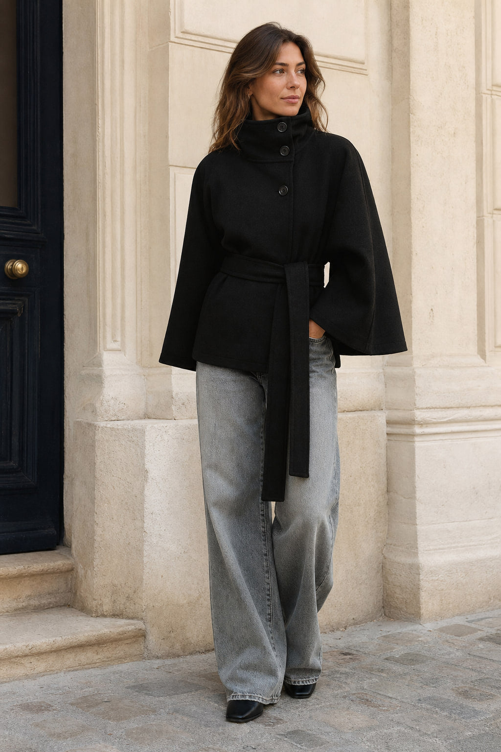 Veste cape noire portée en ville sur un jean large