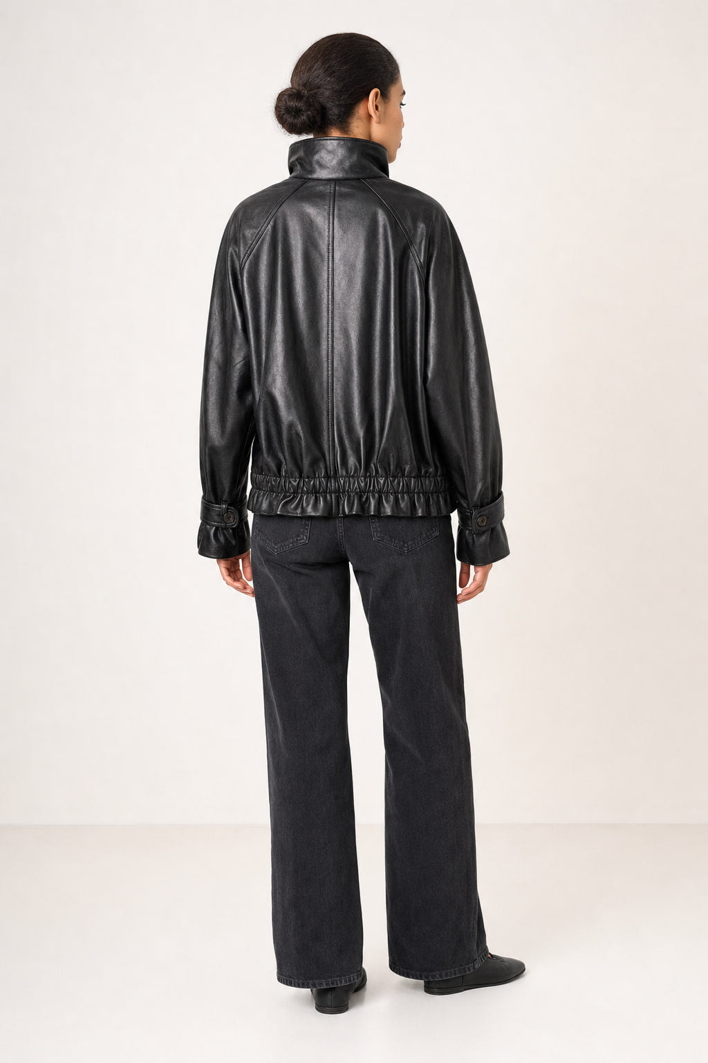 Dos de la veste en cuir noir avec couture centrale et découpes raglan