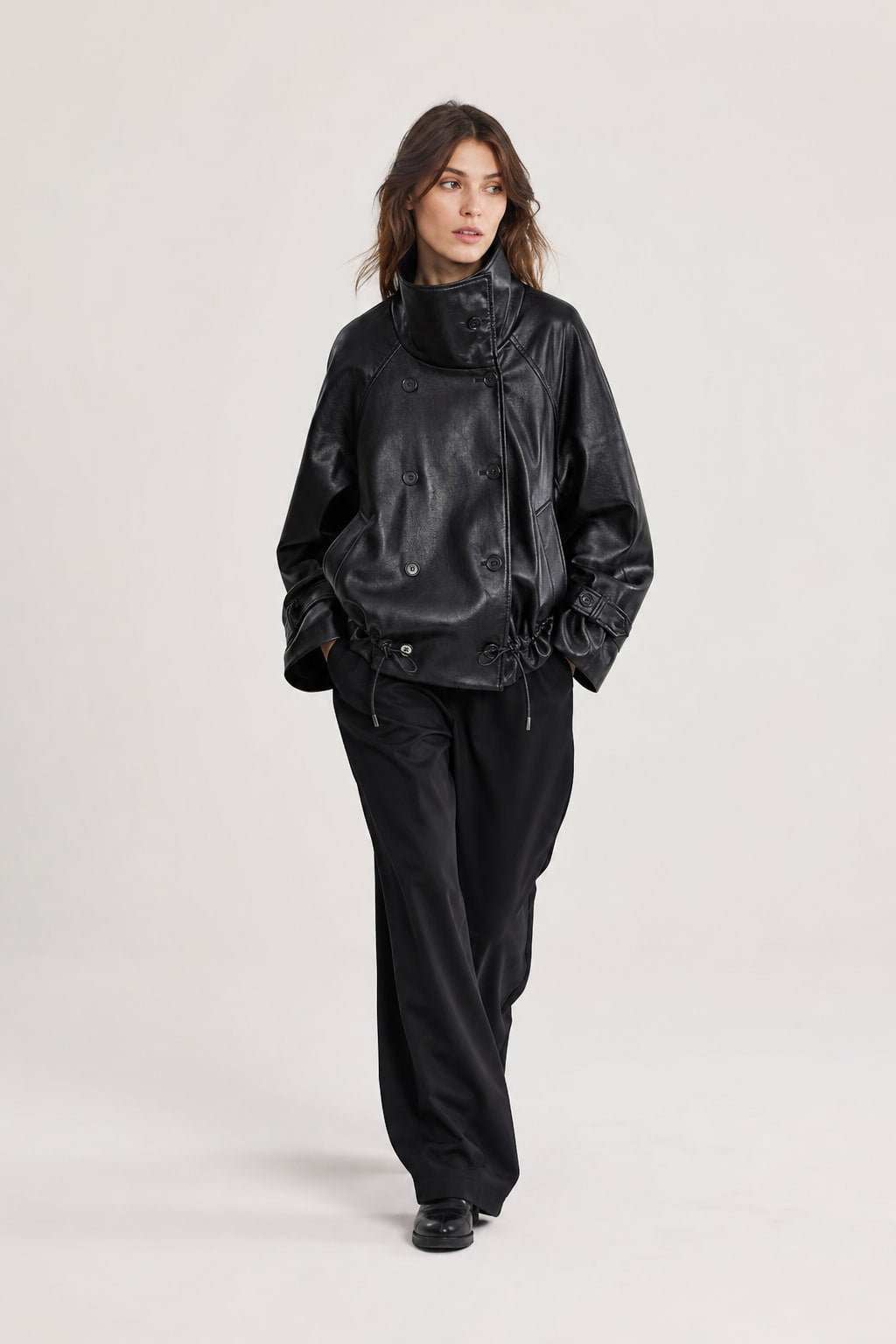 Veste courte en cuir noir en mouvement, manches larges et bas blousant