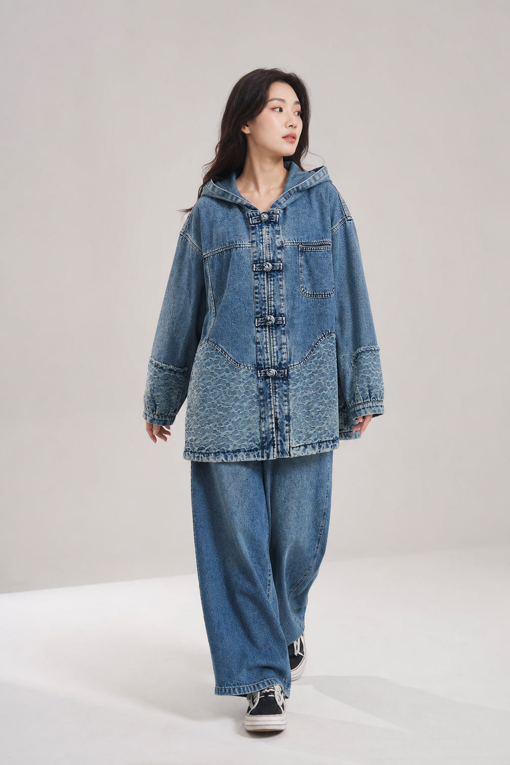 Veste en denim oversize portée en mouvement, volume des manches et de la capuche