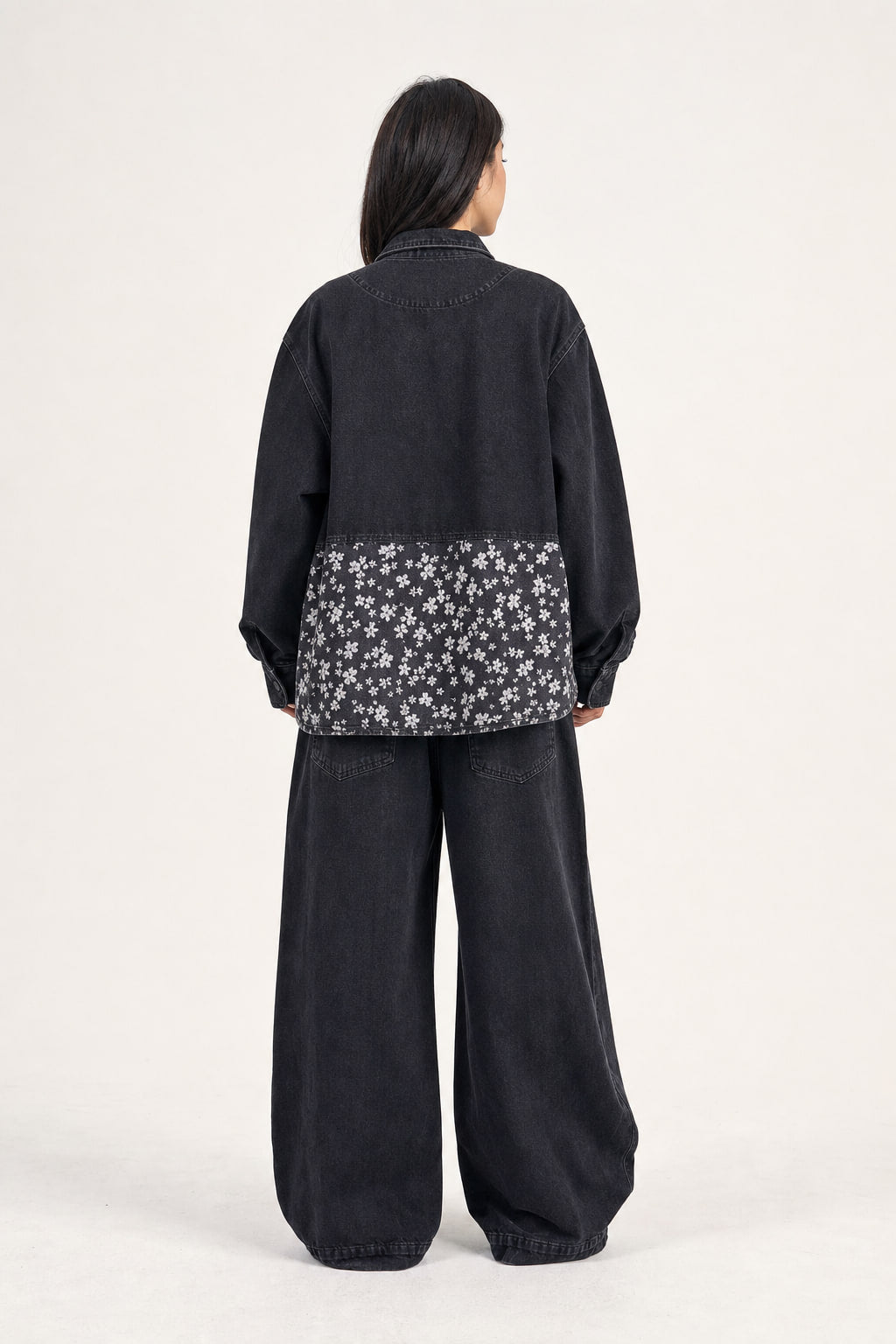 Dos de la veste en denim noir avec découpes et empiècement fleuri