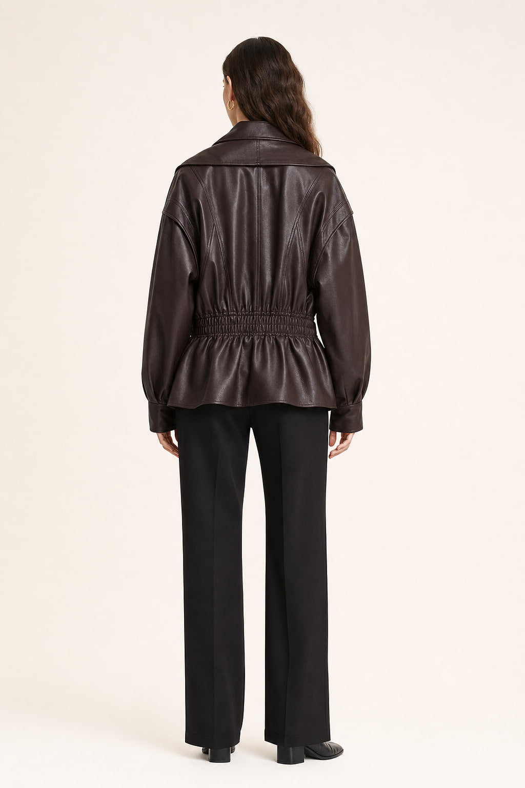 Dos de la veste en simili cuir marron foncé, découpes et bande smockée à la taille