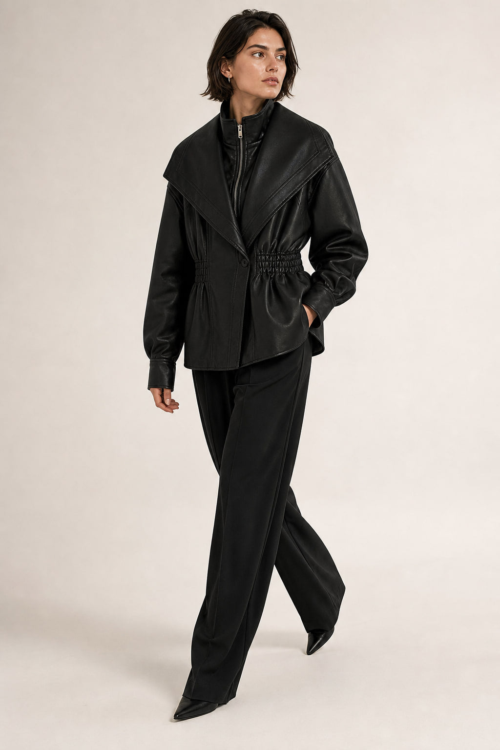 Veste en simili cuir portée en mouvement, effet peplum sur les hanches