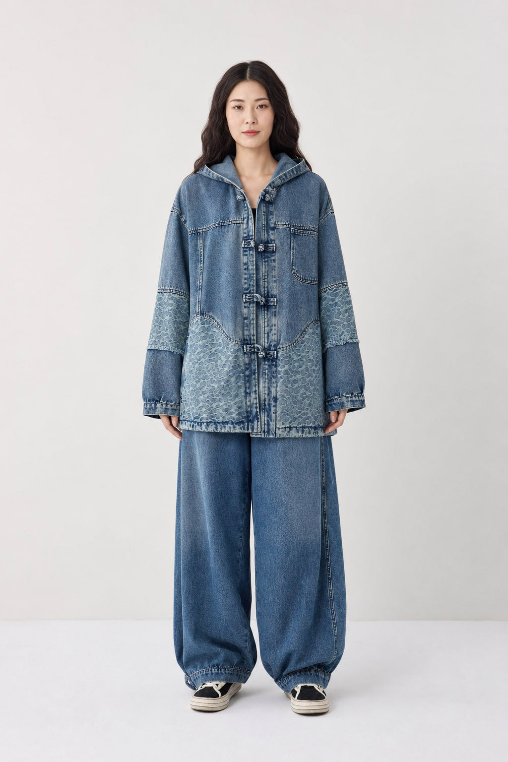 Ensemble denim bleu délavé vu de face, veste à capuche et brandebourgs sur pantalon large