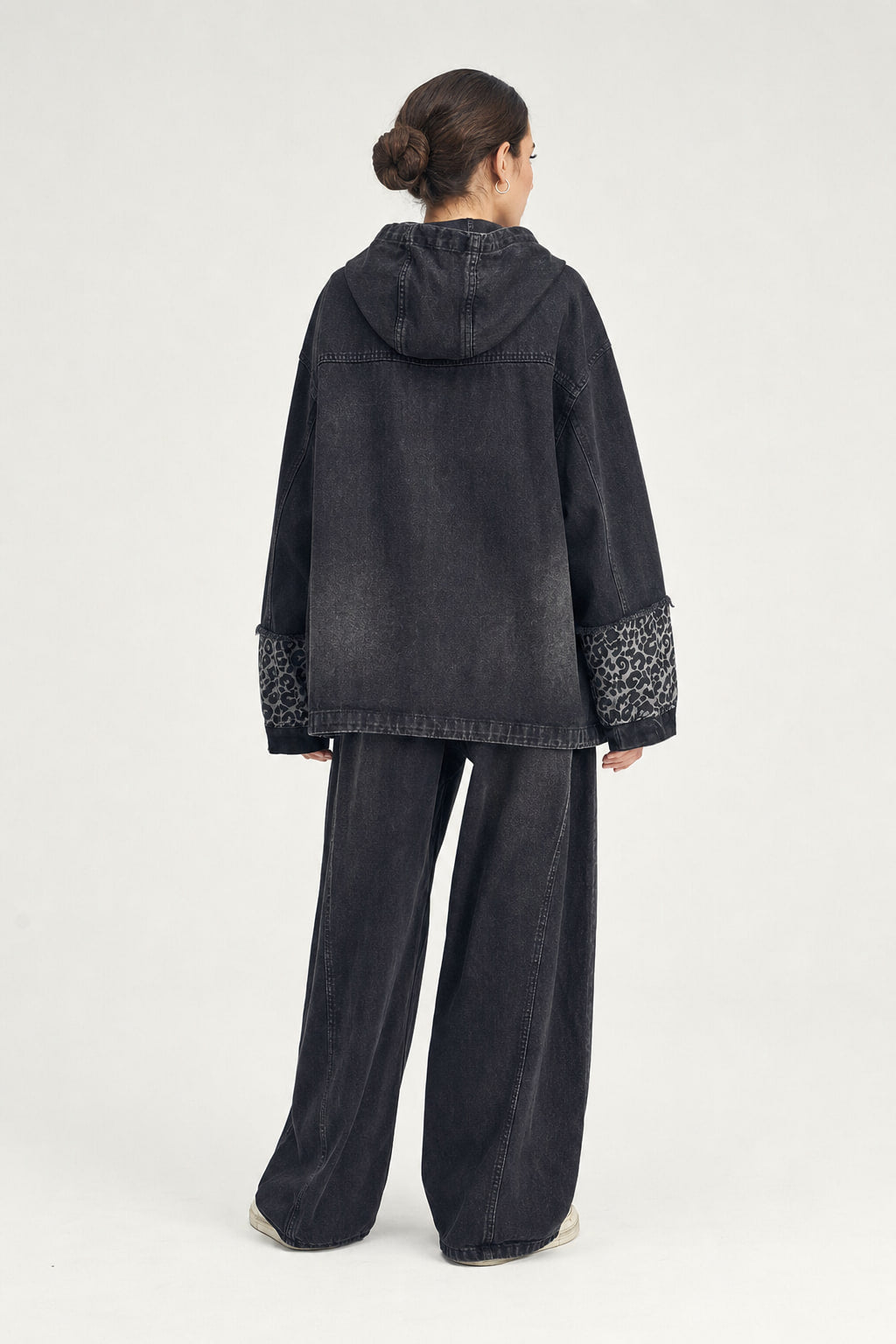 Dos de la veste en denim oversize avec découpes et surpiqûres contrastées
