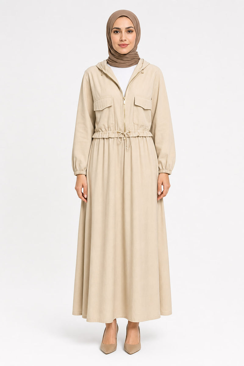 Femme de face portant l'ensemble SQOCH : veste courte zippée à capuche avec cordon de taille et poches à rabat, et jupe longue ample