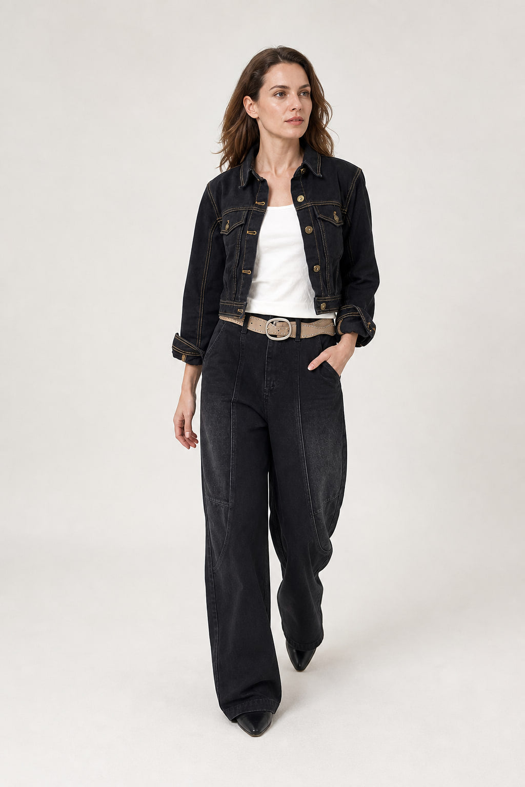 Jean large noir en mouvement, la jambe retombant droite sur la chaussure