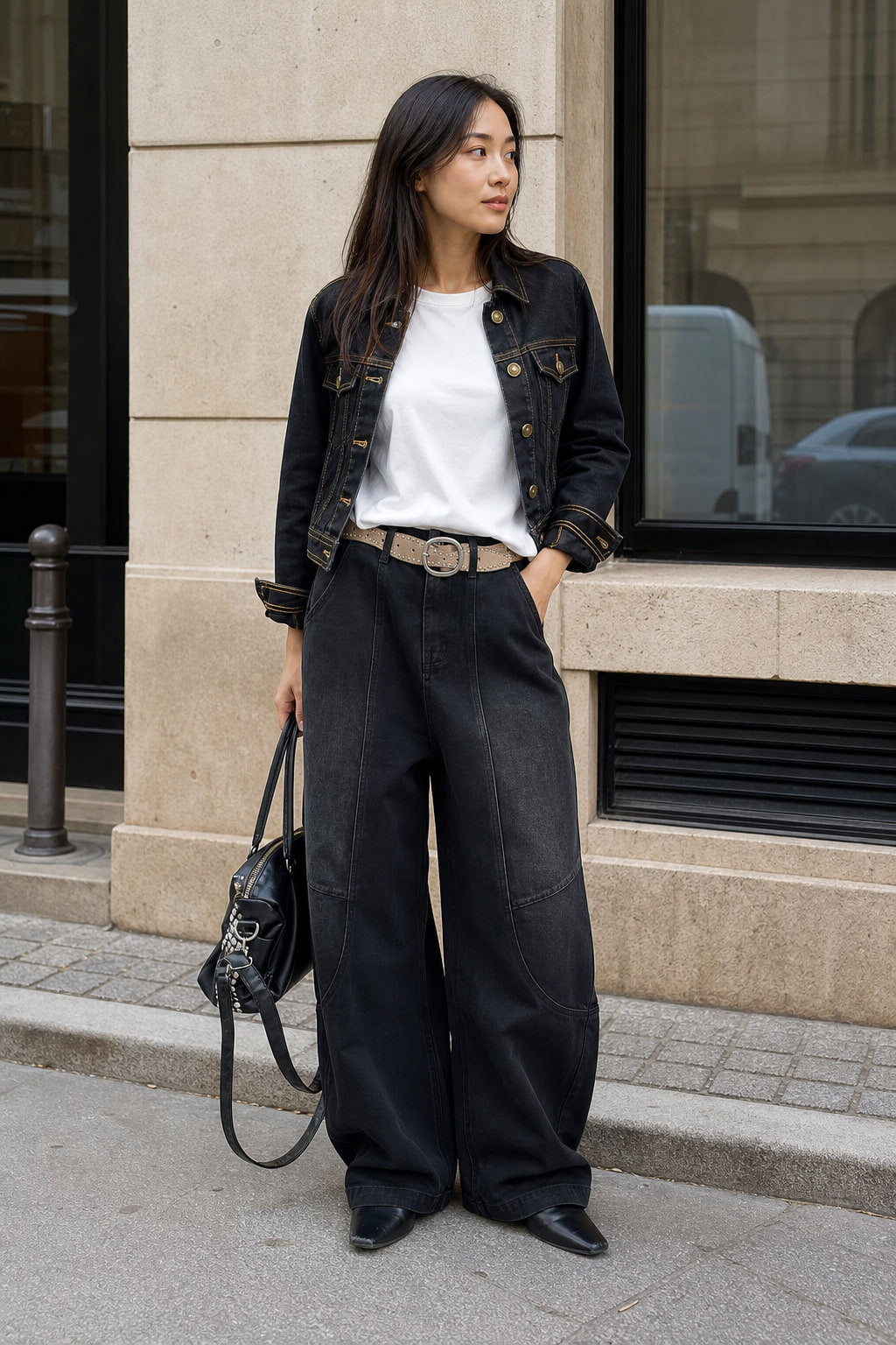 Jean large noir porté en situation, taille haute ceinturée avec un haut ajusté