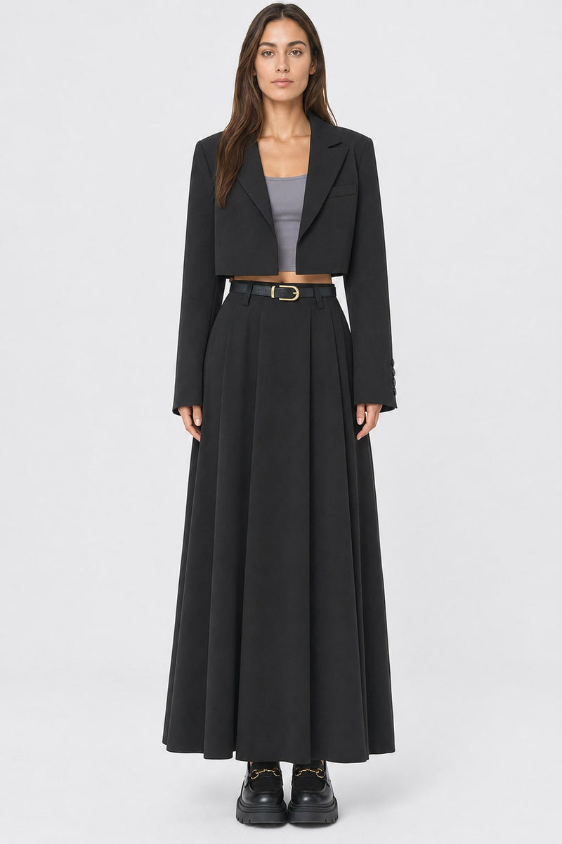 Jupe longue plissée taille haute portée de face, plis creux ouverts sur toute la largeur