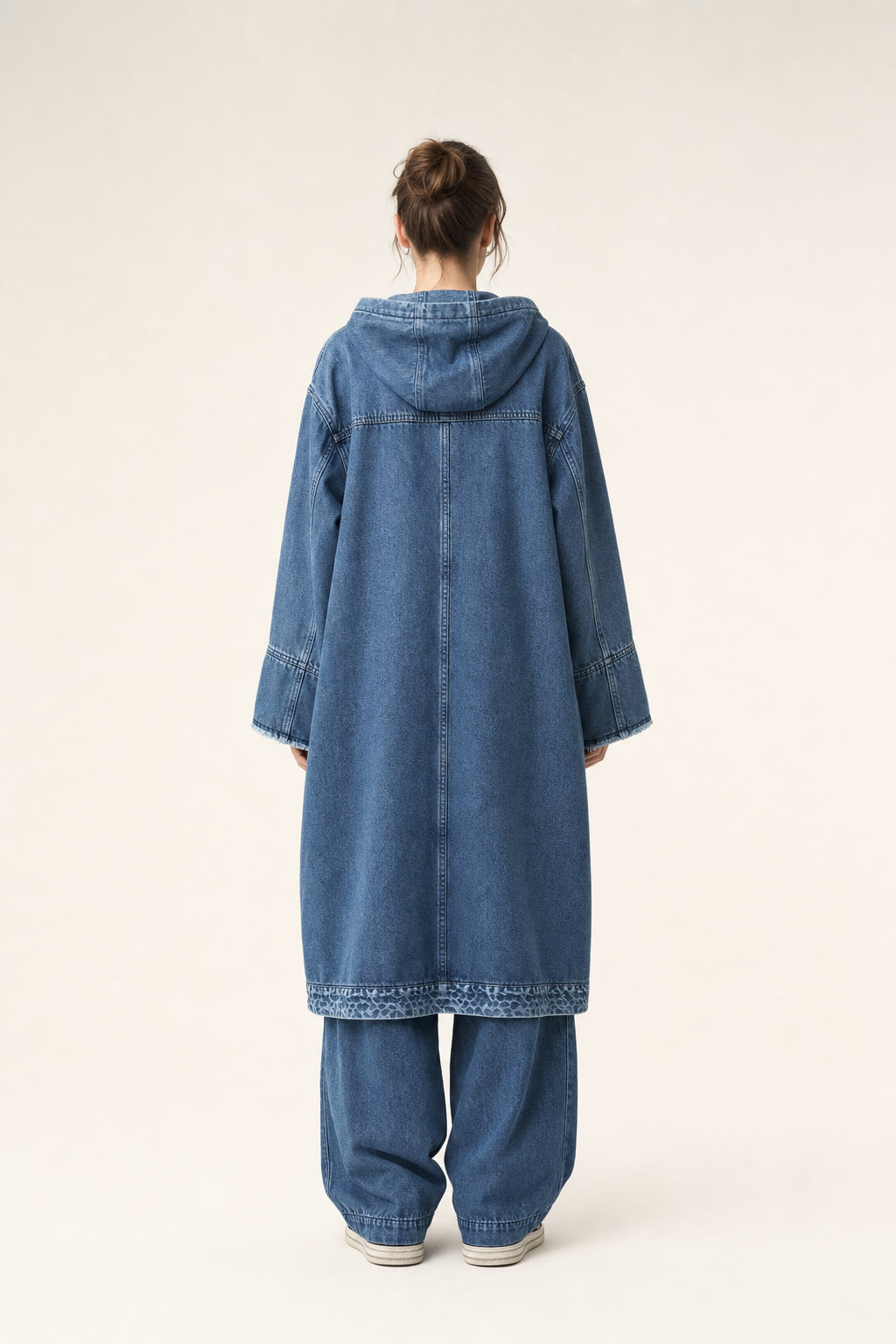 Dos du long manteau en denim à capuche, empiècement et couture centrale visibles