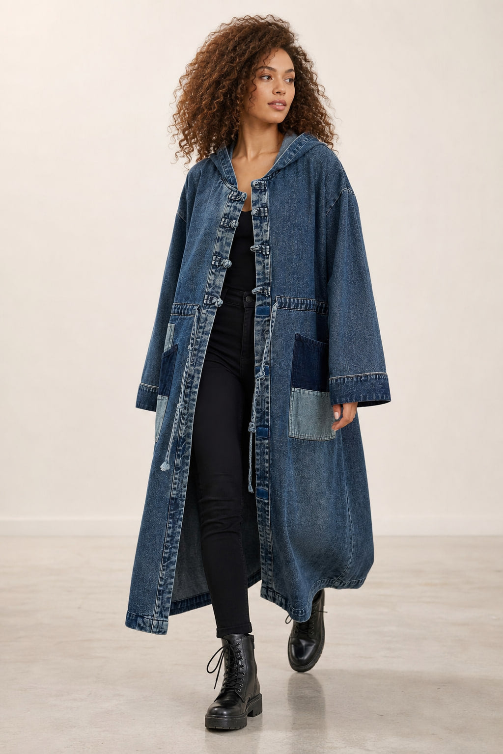 Manteau long en denim bleu en mouvement, pans évasés et longueur sous le mollet