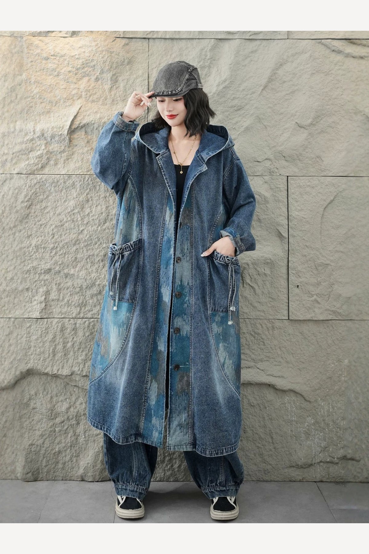 Manteau long en denim porté en marchant, les pans s'ouvrent et révèlent le tombé ample