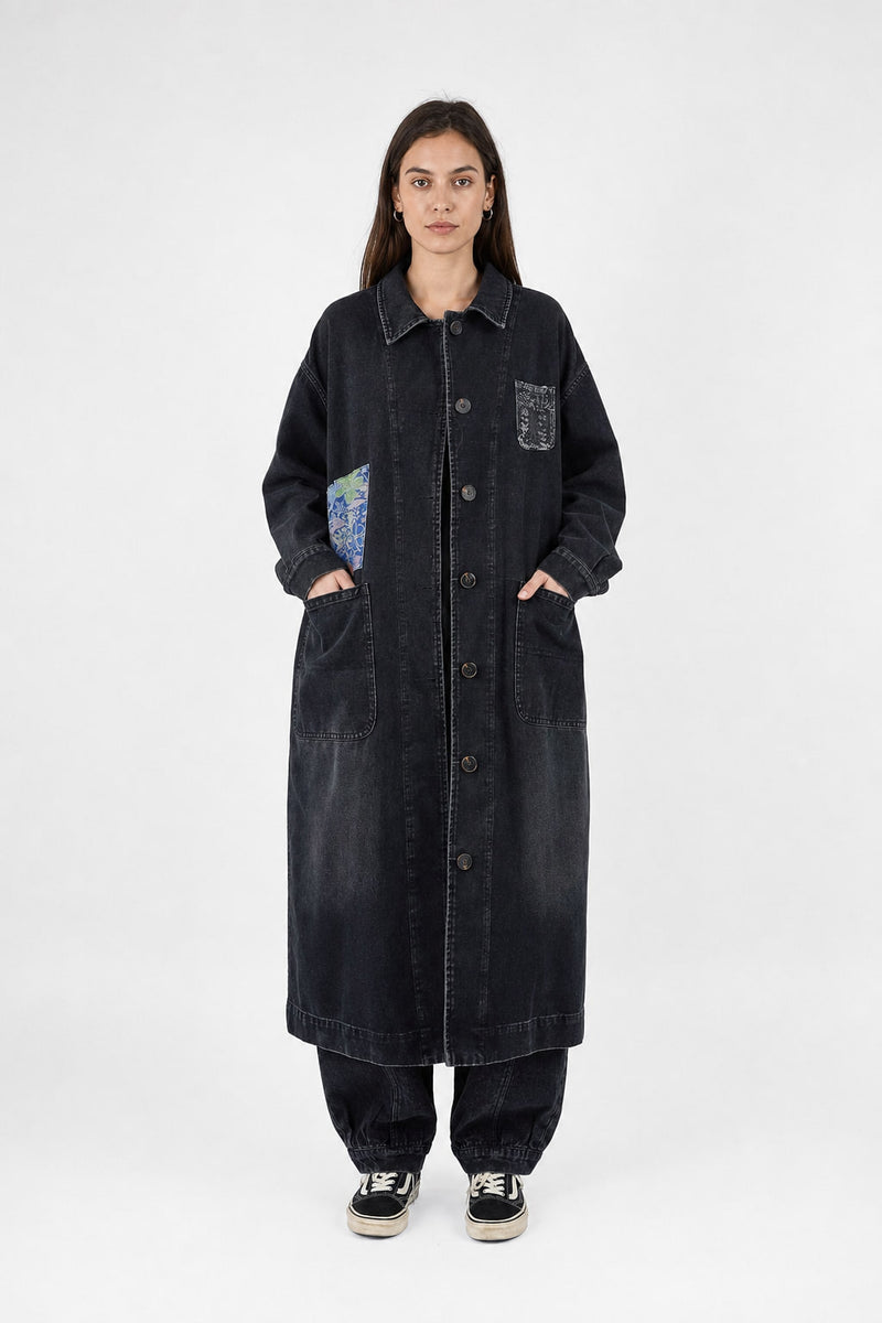 Manteau long en denim délavé noir porté de face, boutonné sur toute la hauteur