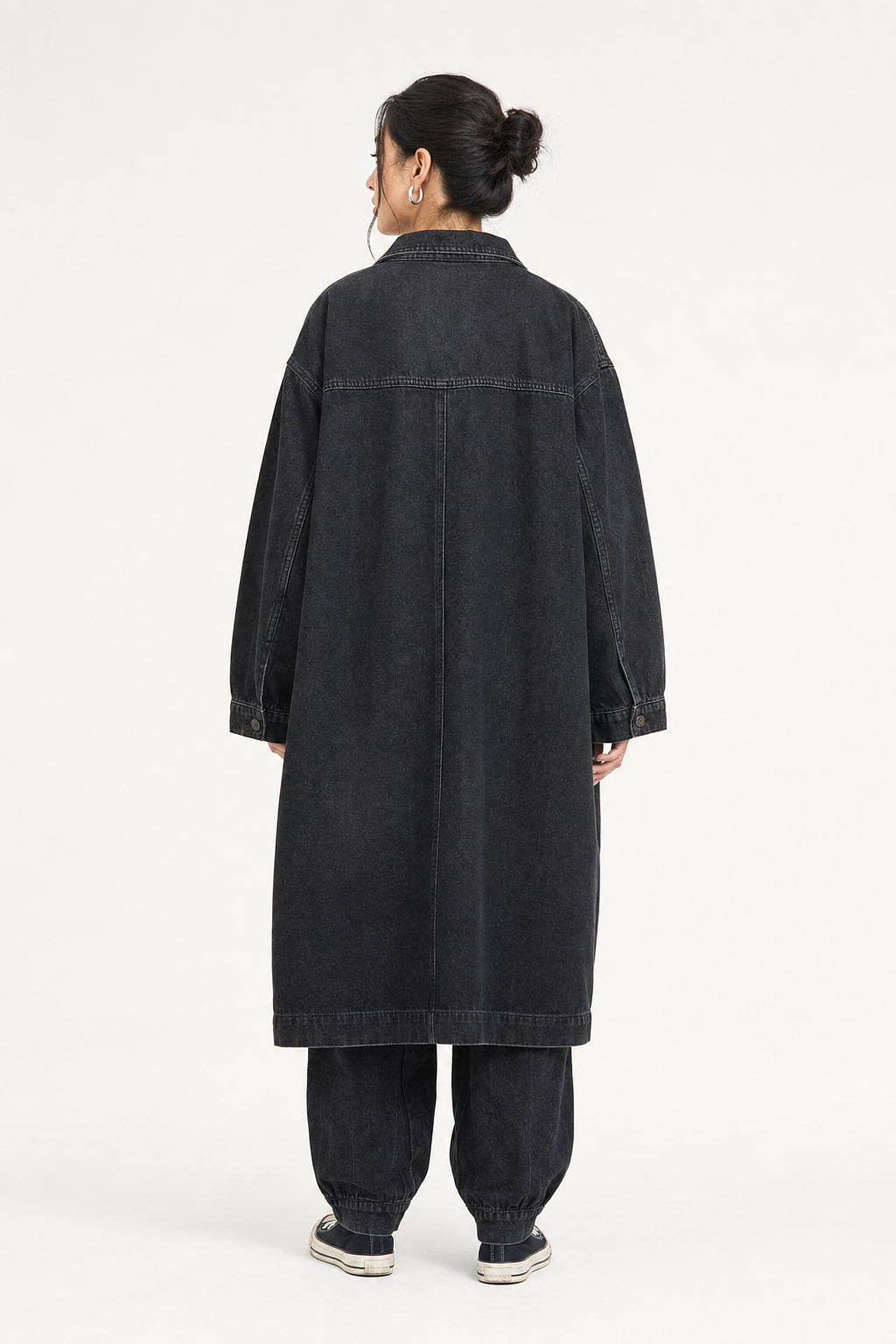 Dos du manteau long noir aspect denim, coupe ample et tombé au mollet
