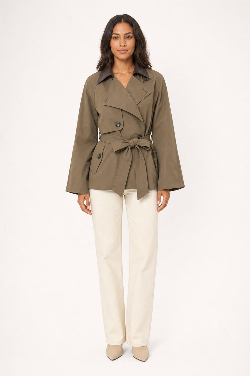 Trench court camel vu de face, col en simili cuir brun et ceinture nouée à la taille