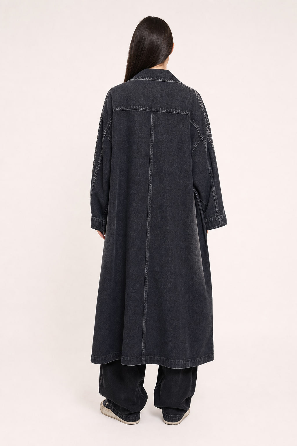Dos du trench long en denim noir avec empiècement pèlerine et surpiqûres ton sur ton
