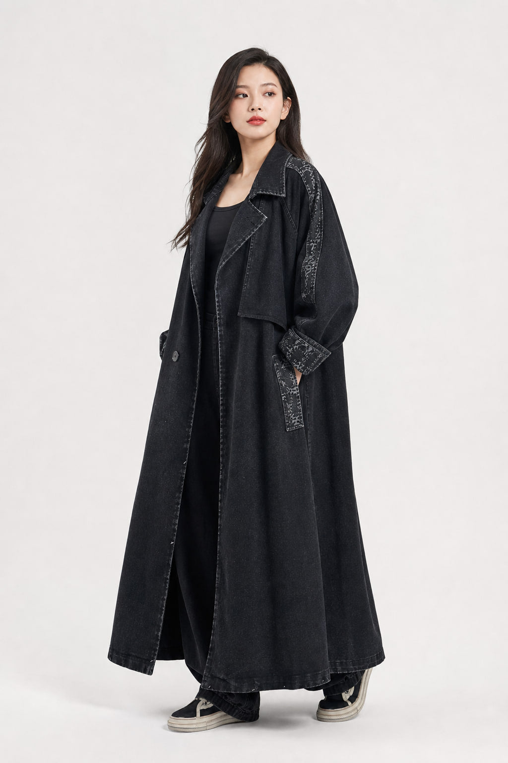 Vue trois-quarts gauche du trench denim noir, bandes délavées le long des manches