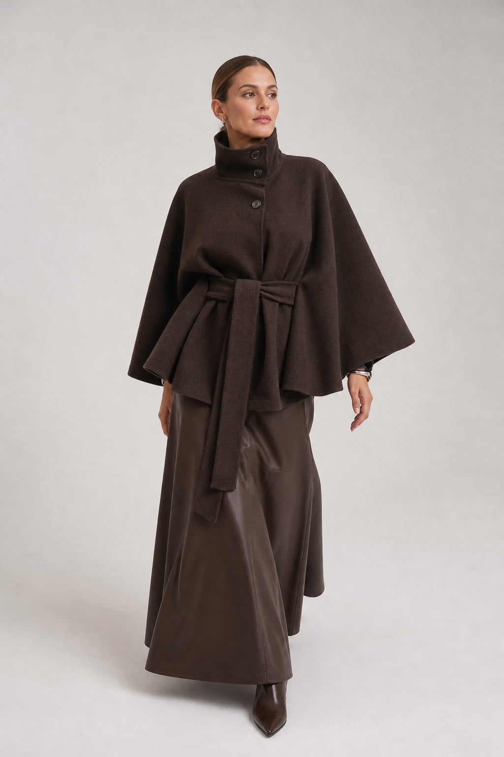 Veste cape marron foncé portée en mouvement, pans de ceinture et manches évasées