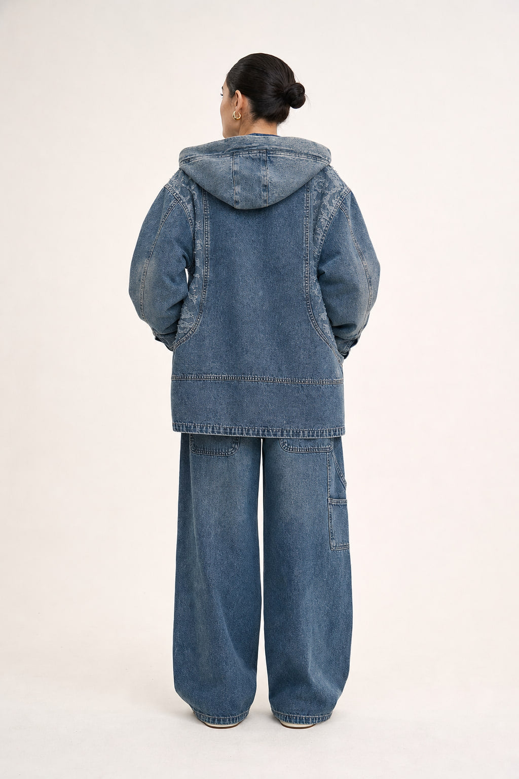 Dos de la veste en denim noir avec couture centrale et découpes
