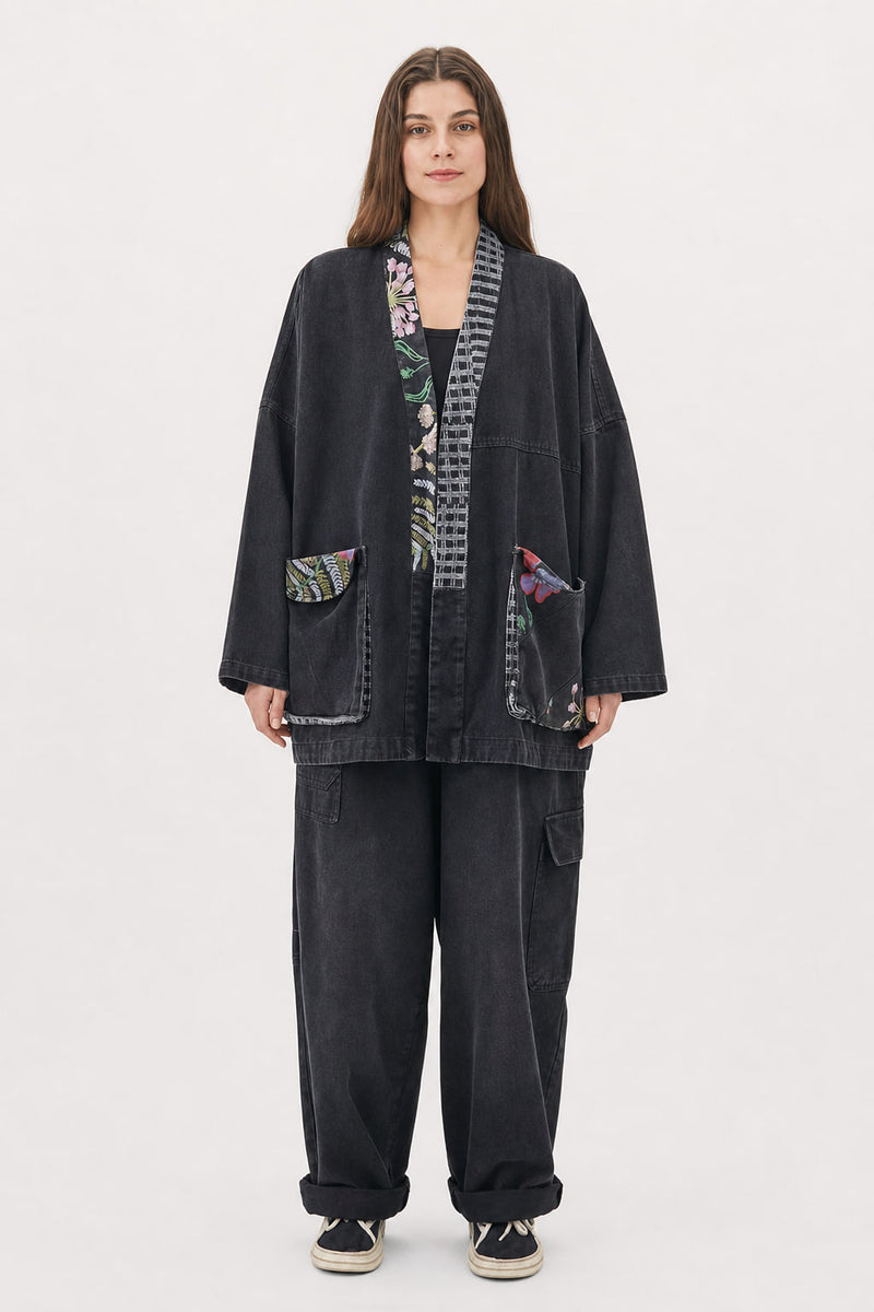 Veste kimono en denim noir délavé portée de face, poches plaquées imprimées