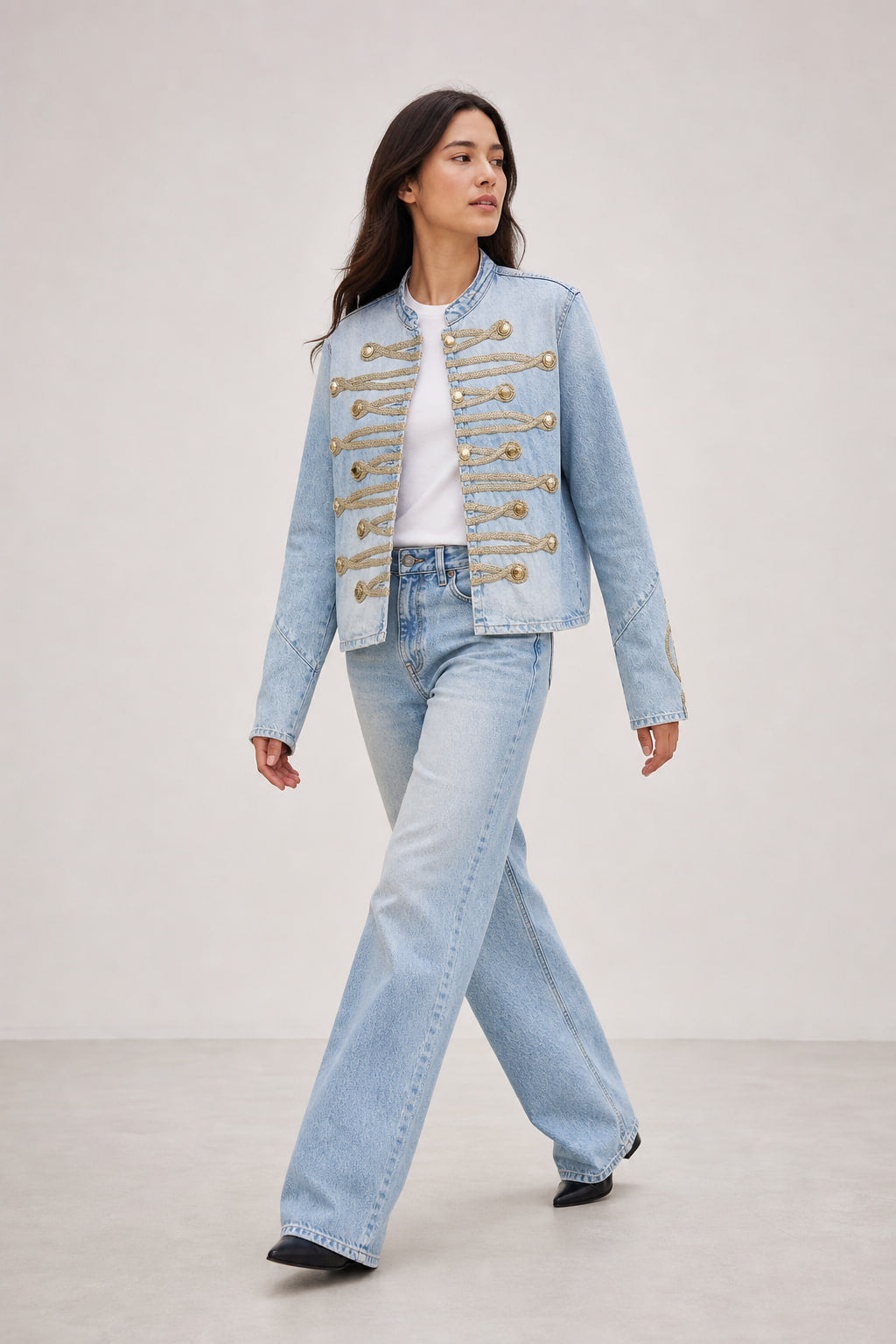 Veste courte en denim clair portée en mouvement, brandebourgs dorés visibles